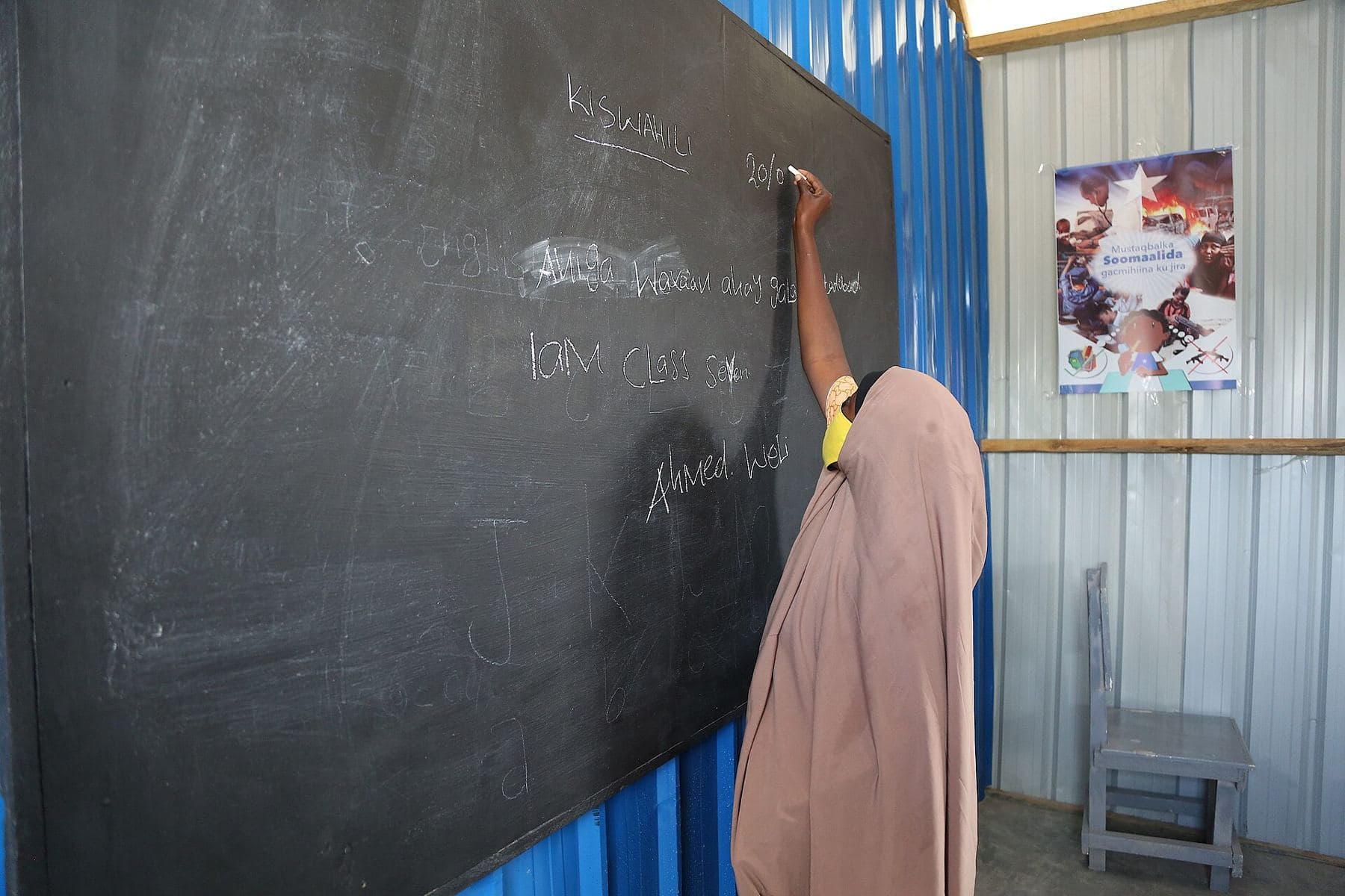 A girl writing on the blackboard in a newly renovated classroom