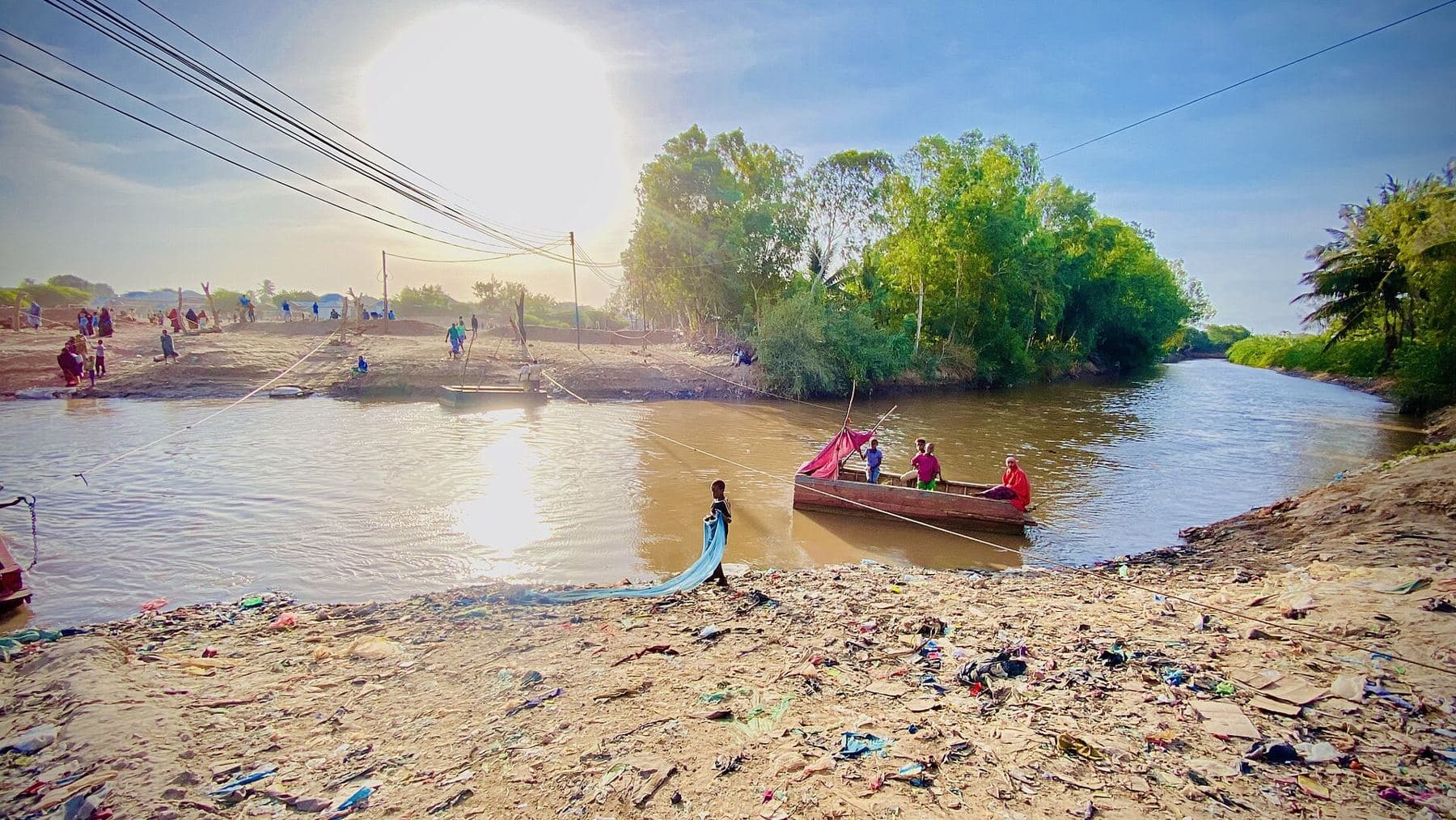 Green riverside farms and a small boat on the Shabelle River at Afgooye